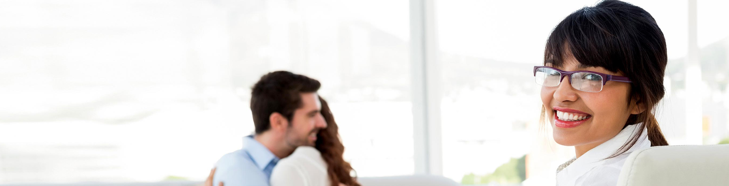 Sicologa sonria mientras una pareja se abraza en segundo plano