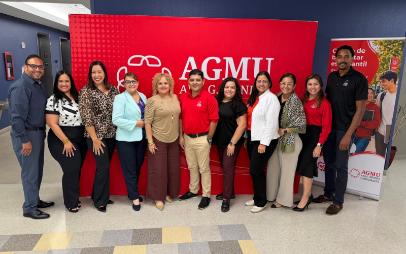 Personas que trabajan en admisiones fronte al logo de AGMU