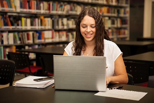 estudiante mujer en biblioteca con laptop - female student in library using laptop
